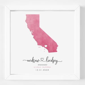 May include: A pink watercolor illustration of the state of California with a small heart in the center. The text "andrew ♥ lindsey" is written below the map, along with the words "ENGAGED", "LA JOLLA, CALIFORNIA", and "12.31.2024".