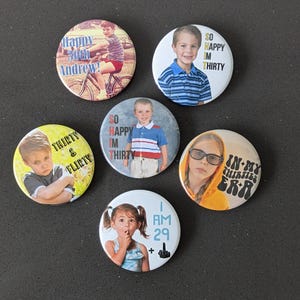 May include: Six round buttons with different images and text. The buttons feature a variety of images, including a child riding a bicycle, a child in a striped shirt, a child with a serious expression, a child with a finger on their lips, and a child wearing glasses. The text on the buttons includes "Happy 30th Andrew!", "So Happy Im Thirty", "Thirty & Flirty", "So Happy Im Thirty", "I Am 29 +", and "In My Thirties Era".