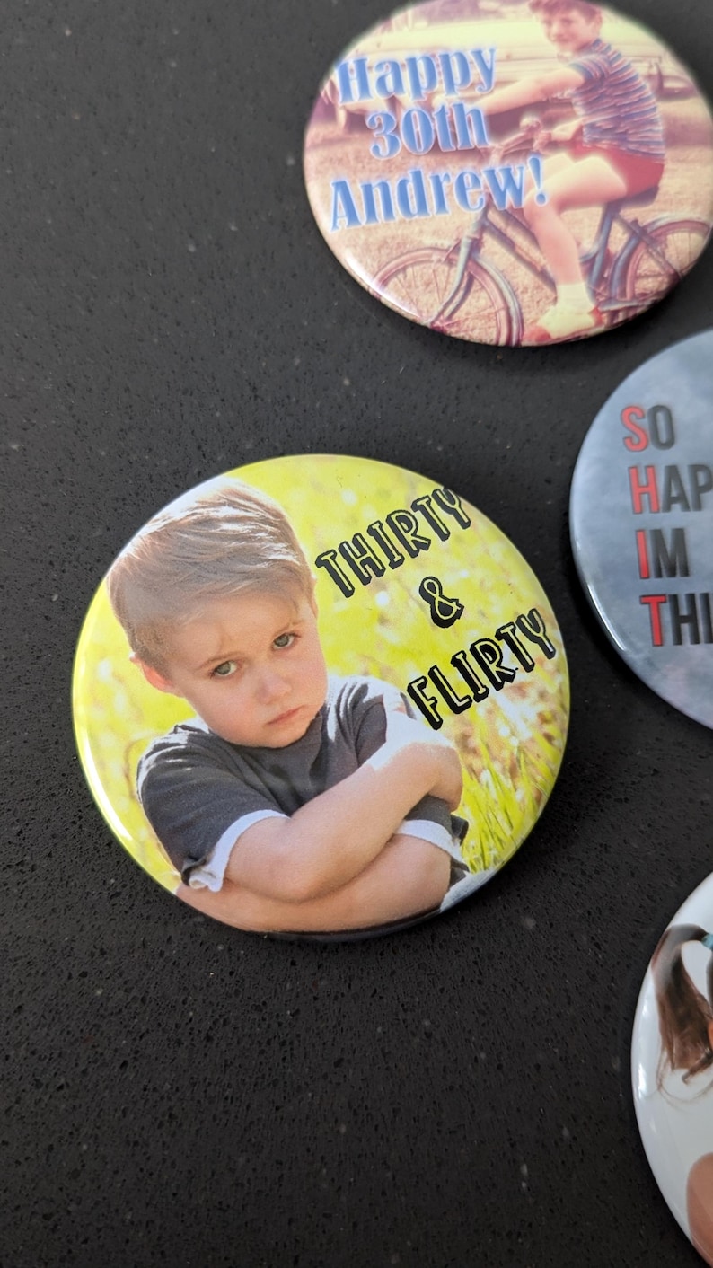 May include: A yellow button with a photo of a young boy with a serious expression. The text "THIRTY & FLIRTY" is printed in black on the button.