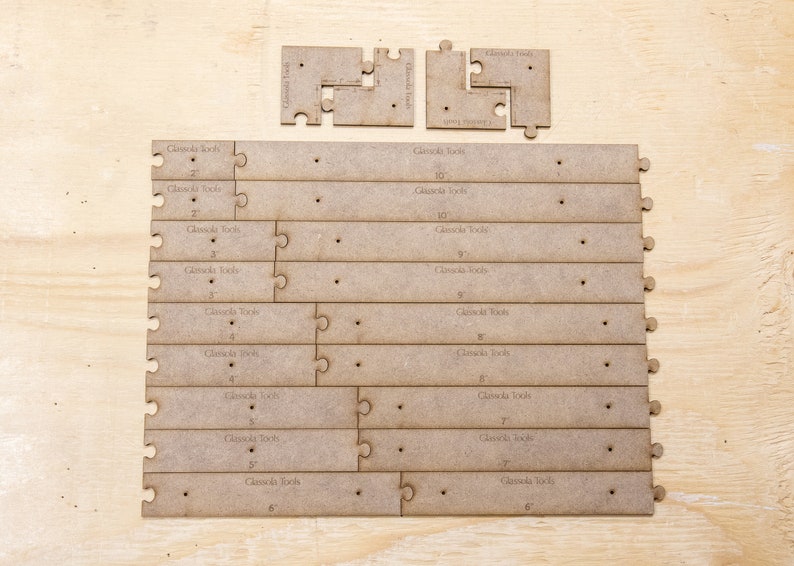 May include: A set of wooden jigsaw pieces for constructing a wooden tool organiser. The pieces are labelled with measurements in inches, including 2, 3, 4, 5, 6, 7, 9, and 10 inches.