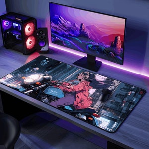 May include: A large black and gray mousepad with a colorful anime illustration of a woman riding a motorcycle. The woman is wearing a pink jacket and headphones. The background is a city street with buildings and streetlights.