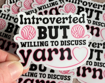 Puede incluir: Un conjunto de pegatinas con el texto "Introvertido pero dispuesto a hablar de lana" y un gráfico de ovillo de lana rosa.