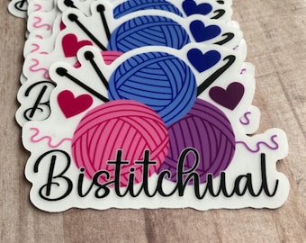 Puede incluir: Una pegatina blanca con un diseño de ovillos de lana rosa, azul y morado. Los ovillos de lana están rodeados por dos agujas de tejer y corazones. El texto "Bistichual" está escrito en negro debajo de los ovillos de lana.