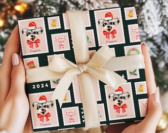 May include: A wrapped gift with a festive dog-themed wrapping paper. The paper features a repeating pattern of dog portraits wearing Santa hats and red bows, with the name "Pepper" below each image. The gift is tied with a gold ribbon and bow, with the year "2024" printed on the wrapping paper.