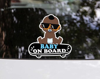 May include: A black and white sticker featuring a cartoon baby wearing sunglasses and a nappy riding a skateboard. The sticker reads "Baby On Board" in white lettering.