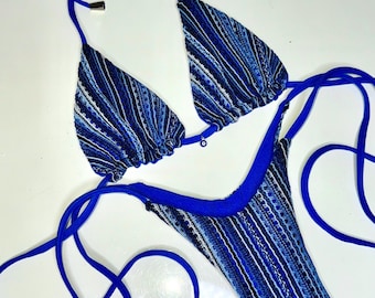 Puede incluir: Un bikini a rayas azules y blancas con tirantes ajustables. La parte superior del bikini tiene forma de triángulo y la parte inferior es de estilo de corte alto.