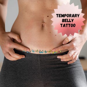 May include: A temporary belly tattoo with a line of colorful butterflies. The text "TEMPORARY BELLY TATTOO" is in a pink starburst shape.