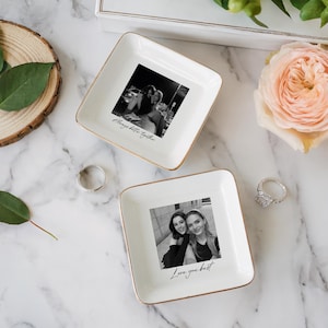 Peut inclure: Deux vide-poches carr&eacute;s en c&eacute;ramique blanche avec des bords dor&eacute;s. Chaque plat pr&eacute;sente une photographie en noir et blanc et un message manuscrit. L'un dit "Always better together" et l'autre "Love you best".