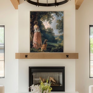 Puede incluir: Una pintura enmarcada de una mujer con un vestido rosa caminando con un perro en un paisaje verde. La pintura está colgada sobre una chimenea.