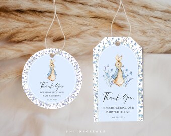 May include: Two blue and white thank you tags with a watercolor illustration of a bunny rabbit wearing a blue jacket. The text on the tags reads "Thank You for showering our baby with love".