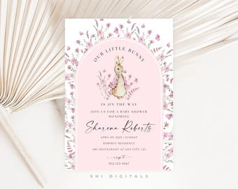 May include: Baby shower invitation with a pink background and floral border. The invitation features a watercolor illustration of a bunny wearing a pink jacket. Text includes "Our Little Bunny Is On The Way" and event details.