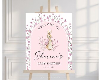 May include: A baby shower welcome sign featuring a watercolor illustration of a bunny in a pink arch. The sign includes the text "Welcome to Sharena's Baby Shower 03.18.2025" and is decorated with floral elements.