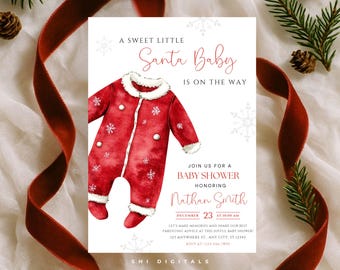 May include: A baby shower invitation with a watercolor illustration of a red Santa suit with white trim and snowflake accents. The text reads "A Sweet Little Santa Baby is on the Way" and invites guests to a baby shower honoring Nathan Smith.