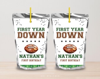 May include: Two silver juice pouches with yellow straws. Each pouch has a football theme with the text "FIRST YEAR DOWN" and "NATHAN'S FIRST BIRTHDAY". A brown football graphic is also featured.