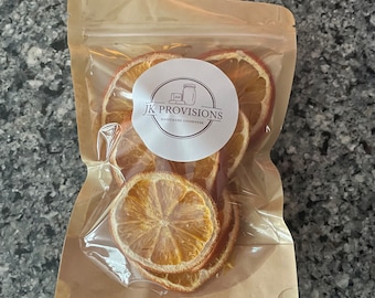 May include: A clear plastic bag filled with dried orange slices. The bag has a brown paper exterior with a white label that reads "JK Provisions Homemade Goodness".