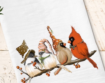 May include: Four birds wearing festive hats perched on a branch with red berries. The birds are a cardinal, a brown bird, and two white birds with black accents.
