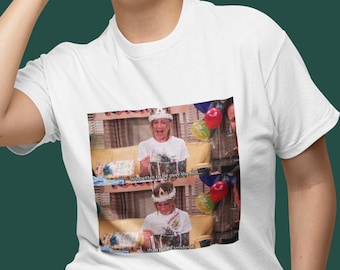 May include: White t-shirt with a printed image of a woman wearing a crown and holding a gift box. The text on the image reads "I'd rather be over the hill, than buried under it!"