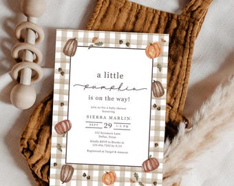 May include: A baby shower invitation with a pumpkin theme. The invitation features a gingham border and pumpkin illustrations. The text reads "a little pumpkin is on the way!" and includes the date, time, and location of the shower.