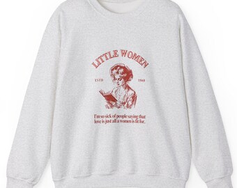 May include: A light gray sweatshirt with a red graphic of a woman reading a book, the words "LITTLE WOMEN" and "ESTD 1868". Below the graphic is the quote, "I'm so sick of people saying that love is just all a women is fit for."