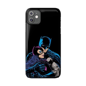 Könnte beinhalten: Eine schwarze Handyhülle mit einem Grafikdruck von Batman und Catwoman, die sich umarmen. Der Hintergrund ist schwarz.