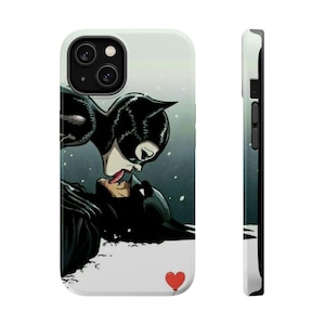 May include: A phone case with a graphic of Catwoman kissing Batman. The background is a snowy scene with a red heart.