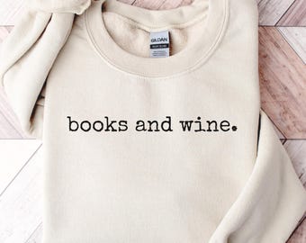 May include: A beige sweatshirt with the text "books and wine." printed in black.