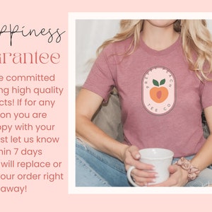 May include: A pink t-shirt featuring a peach graphic and the text "PREPPY PEACH TEE CO.". The shirt is being worn by a person sitting on a sofa.