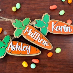 Three examples of 3D carrot Easter basket tags for kids, personalized with their first names.
