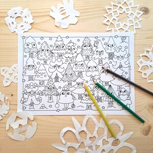 May include: A black and white Christmas-themed colouring page featuring cartoon Christmas trees with numbers. Several white paper snowflakes and three coloured pencils are scattered around the page on a wooden surface.