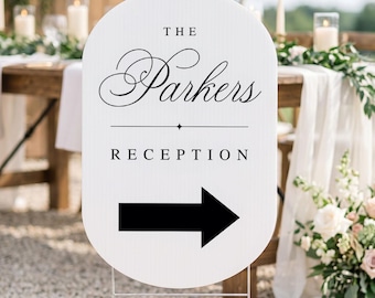 May include: A white oval sign with rounded edges featuring the black text THE Parkers RECEPTION and a large black arrow pointing to the right. The sign is mounted on a thin metal wire stand and displays a clean, high-contrast design.