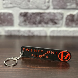 Llavero de 21 Pilots. 10 cm de largo, 2,5 cm de ancho y 0,8 cm de grosor. ¡Impresora 3D con plástico multicolor! Incluye cadena y anilla.