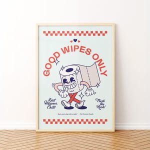 May include: A framed print with a light blue background features a cartoon toilet paper roll with arms and legs. The text "GOOD WIPES ONLY" is in red, with additional text: "Shit Happens. Chill!" and "Flush the Rush!"