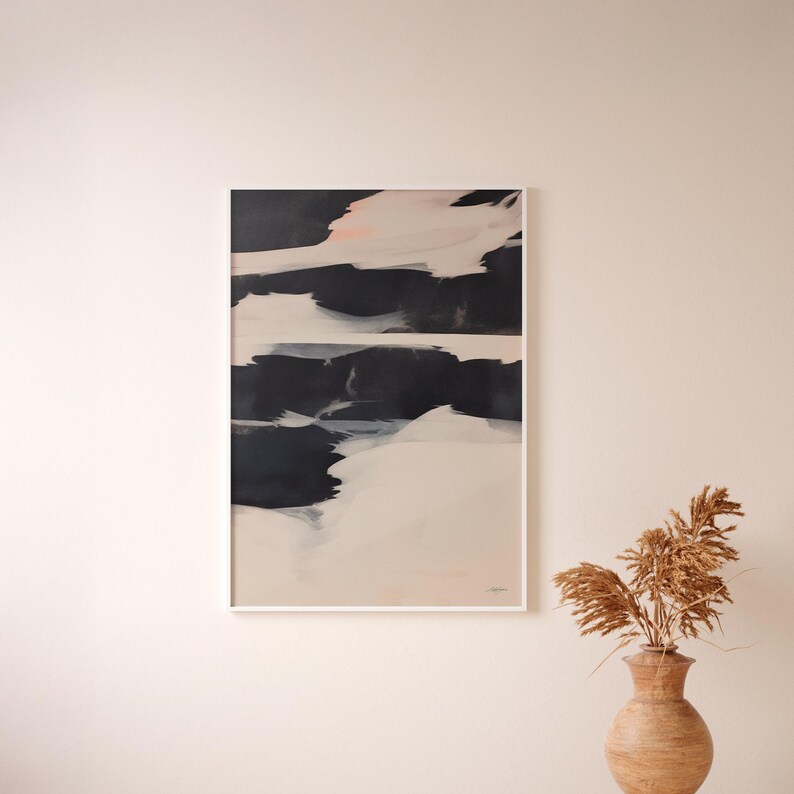 May include: Abstract art print in a white frame. The artwork features bold brushstrokes of black, white, and beige, with a touch of pink. The composition is a modern, minimalist design, suitable for home decor.