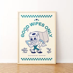 May include: A framed poster with a vintage cartoon toilet paper roll character. The poster reads "GOOD WIPES ONLY" in teal, with additional text: "Shit Happens. Chill!" and "Flush the Rush!" The background is cream-colored with teal accents.