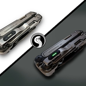 May include: Two Leatherman ARC multi-tools are displayed, one with a green light illuminated. The tools are silver and black, with the text "LEATHERMAN ARC" visible. A white snake logo is centered between the tools against a white and gray background.