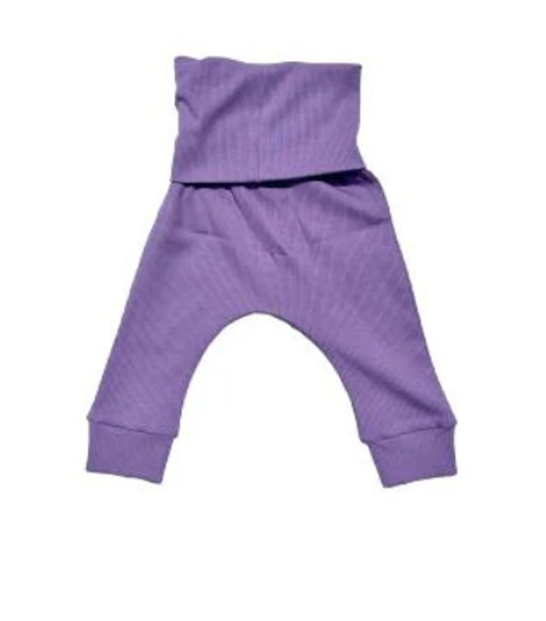 May include: Lavender-colored baby pants with a ribbed texture. The pants have a wide, folded waistband and fitted cuffs at the ankles. The design is simple and comfortable, suitable for infants and toddlers.