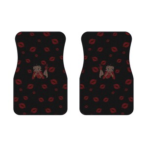 May include: Pair of black car floor mats with a pattern of red lips and a Betty Boop graphic. The mats are designed to fit the front of a vehicle and provide protection from dirt and wear.
