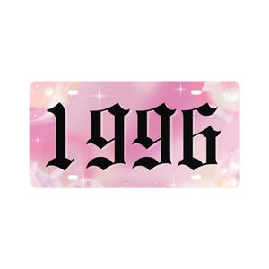 Op de afbeelding: Een rechthoekige nummerplaat met een roze en witte gradiënt achtergrond. De zwarte tekst "1996" wordt weergegeven in een gotisch lettertype. De achtergrond heeft een zachte, dromerige kwaliteit met subtiele ster- en bloemaccenten.