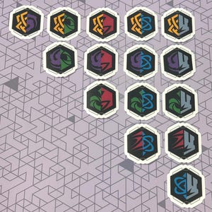 May include: A collection of hexagonal stickers with a black border and white background. Each sticker features a unique design in various colors, including purple, green, red, blue, and yellow. The stickers are arranged on a patterned purple surface.