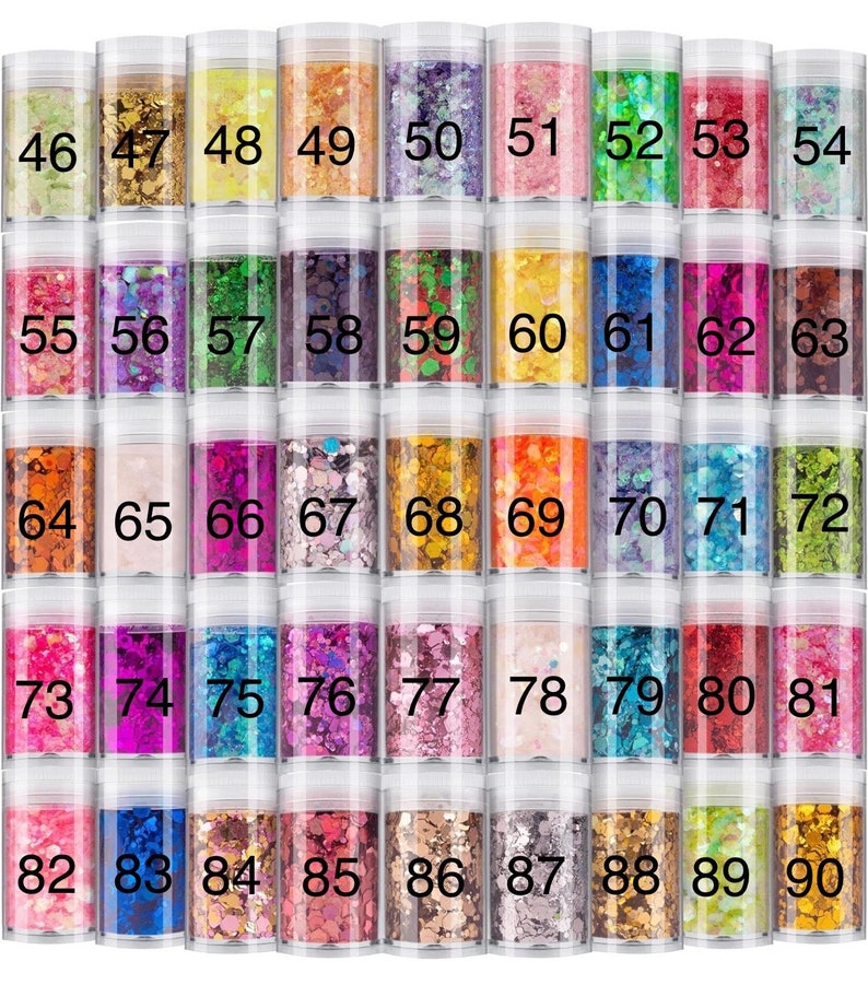 May include: A collection of forty-five clear cylindrical jars filled with various colors of decorative craft glitter. Each jar is labeled with a black number ranging from 46 to 90, showcasing a wide spectrum of hues including gold, pink, blue, green, and purple.