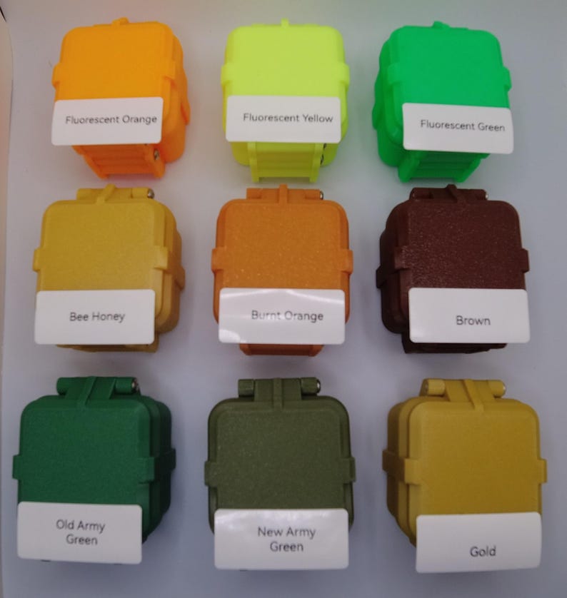 May include: Nine small square containers with different colored paint samples. The colors are fluorescent orange, fluorescent yellow, fluorescent green, bee honey, burnt orange, brown, old army green, new army green, and gold.
