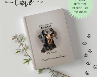 Puede incluir: Un diario beige con una ilustración de un dachshund negro y marrón. El texto "Life is Better With Dachshunds" está impreso sobre el perro. El texto "Winston" está impreso debajo del perro. El texto "Daily Gratitude Journal" está impreso debajo del nombre del perro.