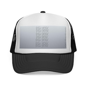 May include: A black and white trucker hat with a curved peak. The front panel is white with a grey rectangle featuring the words "NEW YORK" in a repeating script. The back is black mesh.