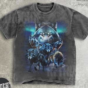May include: Dark gray t-shirt featuring a wolf pack design. The graphic includes multiple wolves in shades of gray and blue, set against a backdrop of a forest and aurora borealis. The shirt has the text "RETROCIDE STREETWEAR".