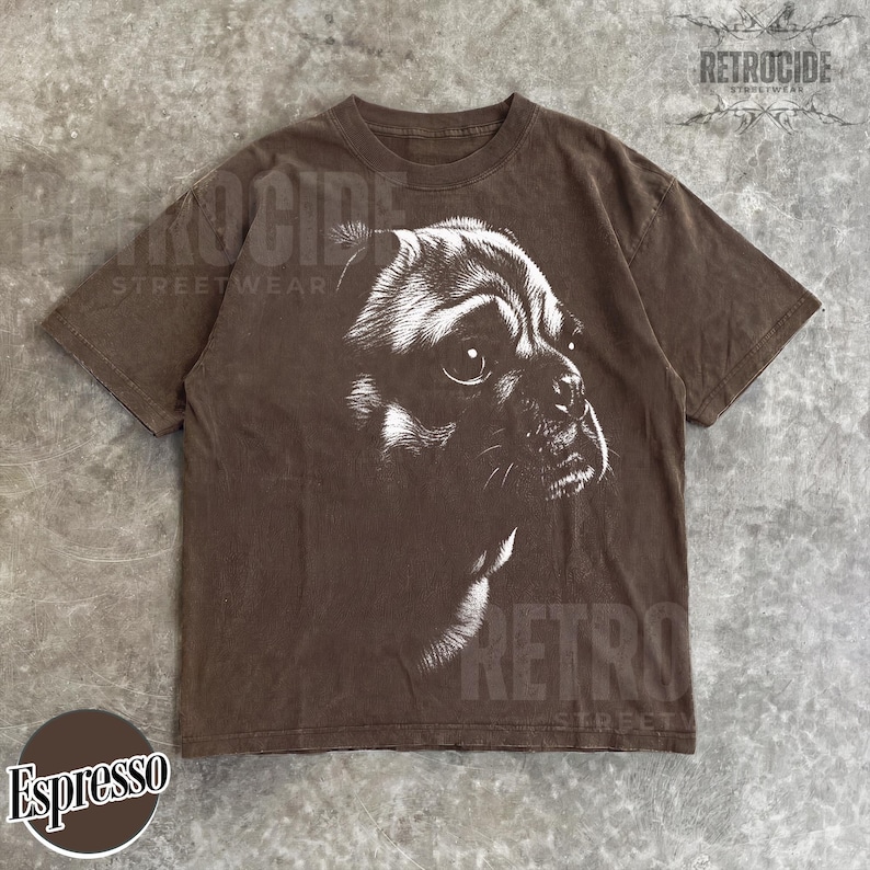 May include: A brown short-sleeve t-shirt featuring a white graphic illustration of a pug dog's face in profile. The shirt has a crew neckline and a faded, washed appearance. The text RETROCIDE STREETWEAR is visible in the top right corner.