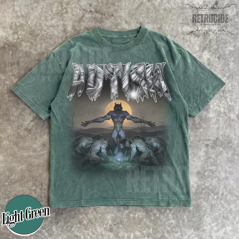 May include: A light green short-sleeve t-shirt featuring the word AUTISM in a metallic, jagged font at the top. Below the text is a graphic of a central werewolf figure with arms outstretched against a full moon, surrounded by four other wolf-like creatures.