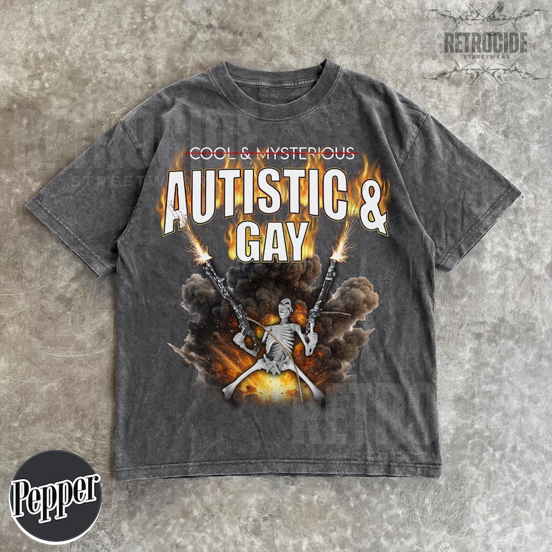 May include: Dark gray t-shirt with the text "COOL & MYSTERIOUS AUTISTIC & GAY" above a graphic of a skeleton holding two guns with flames and smoke. The shirt has a vintage, distressed look.