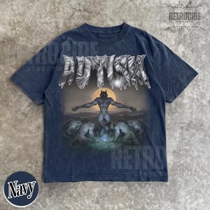 May include: A navy blue short-sleeve t-shirt featuring the text AUTISM in a metallic, jagged font at the top. The graphic depicts a central werewolf figure with arms outstretched against a full moon, surrounded by other werewolf figures in a dark landscape.