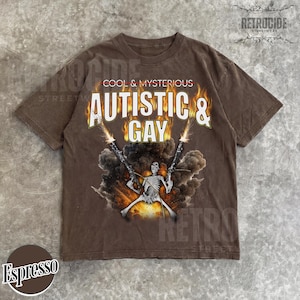 May include: Espresso-colored t-shirt with the text "COOL & MYSTERIOUS AUTISTIC & GAY" in white. A skeleton figure is holding two guns with flames and smoke. The shirt has a vintage streetwear style.