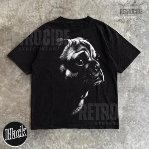 May include: A black short-sleeve t-shirt featuring a high-contrast white graphic illustration of a dog's face on the front. The design shows the detailed profile of a dog with large eyes and whiskers. The text RETROCIDE STREETWEAR is visible.